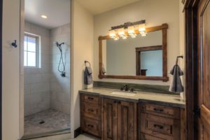 Harrison Residence #1 Rustic bathroom with shower and wooden vanity.