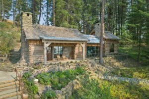 Rustic log cabin in a forest setting with garden.