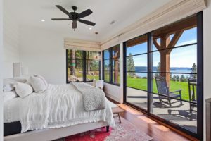 Bright bedroom with lake view and large windows.