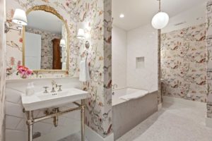 Vintage floral bathroom decor with elegant white tub.