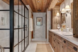 Rustic bathroom with wood accents and glass shower.
