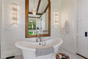 Elegant bathroom with freestanding tub and mirror.