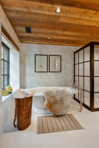 Rustic bathroom with clawfoot tub and decor.
