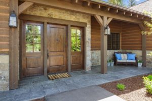 Wooden cabin porch with rustic wooden door.
