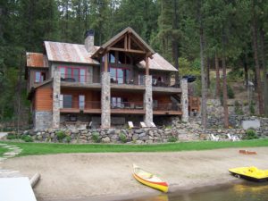 Everwell Bay Remodel Rustic lakeside cabin with canoes on the sandy beach.