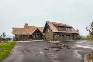 Rustic wooden house with driveway and garage.