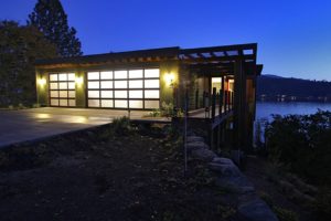 Liberty Lake Residence Modern lakefront home at dusk with glowing lights.