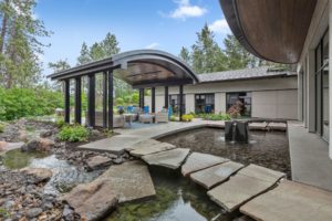 Modern patio with garden and water feature.