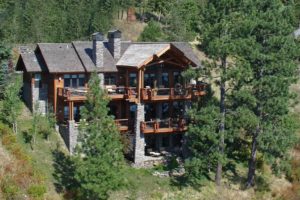 Rustic hillside lodge surrounded by lush trees.