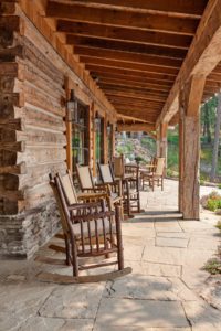 Rustic log cabin porch with wooden rocking chairs