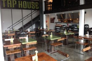 Modern tap house interior with wooden tables and chairs.