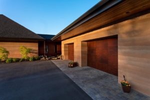 Lake Fernan Residence - Passive House Institute Certified Modern home with wooden garage doors.