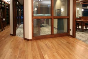 Office with glass walls and wooden flooring