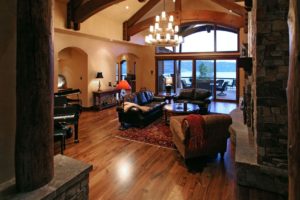 Spacious living room with wooden beams and lake view.