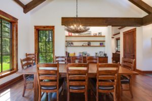 Rustic dining room with wooden furniture and chandelier.