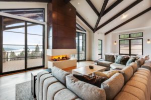 Modern living room with fireplace and large windows.