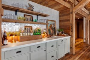 Rustic home bar with shelves and decor items.