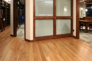 Office with wooden floors and glass walls.