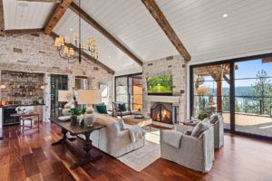 Chic rustic living room with fireplace and lake view.