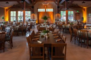 Rustic banquet hall with wooden chairs and tables.