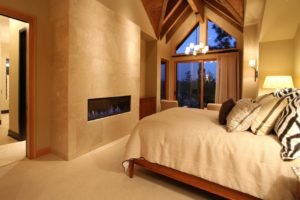 Cozy bedroom with modern fireplace and large window