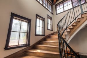 Harrison Residence #1 Curved wooden staircase with large windows.