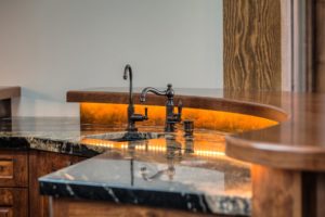 Harrison Residence #1 Luxurious marble kitchen sink with warm lighting.