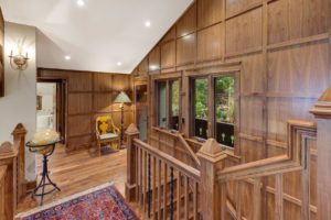 Hayden Lake Chalet Cozy wooden-paneled hallway with staircase.