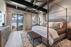 Elegant bedroom with lake view balcony.