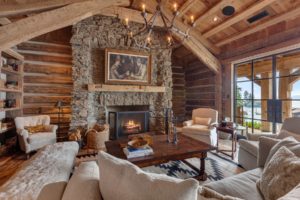 Rustic cozy cabin living room with stone fireplace.