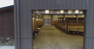 Horse arena interior with warm lighting.