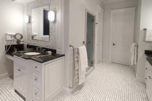 Everwell Bay Remodel Elegant white bathroom with black countertop.