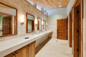 Hayden Lake Country Club Refresh Modern bathroom with wooden accents and mirrors.