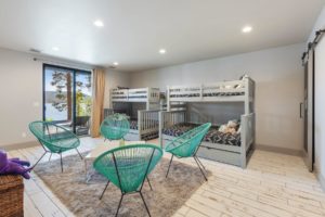 Modern lakeview bedroom with bunk beds and chairs.