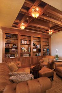 Elegant library with leather seating and wooden shelves.