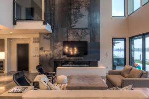 Modern living room with large TV and fireplace.