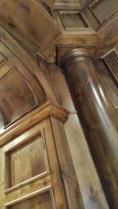 Ornate wooden column and paneled ceiling design.