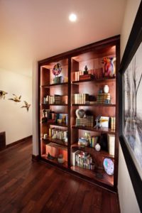 Lake Fernan Residence - Passive House Institute Certified Wooden bookshelves with decor and books in a cozy room.