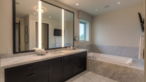 Modern bathroom with marble countertop and tub.
