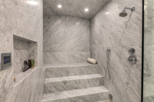 Luxurious marble steam shower with seating.