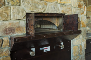 Rustic stone oven with open doors.