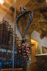 Decorative wine cellar door handle in grape design