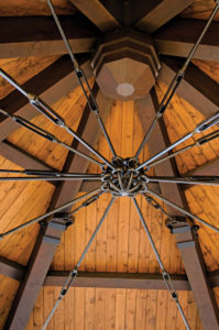 Wooden gazebo roof with metal support cables.