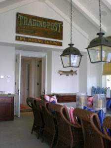 Rustic dining room with wicker chairs and hanging lights.