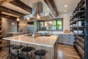 Rustic kitchen with modern island and log beams.