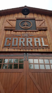 The Corral rustic wooden barn entrance sign.