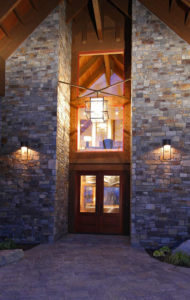 Modern stone house entrance with warm lighting.
