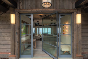 Modern glass doors open to cozy living room.