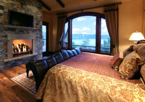 Cozy lakeside bedroom with fireplace view