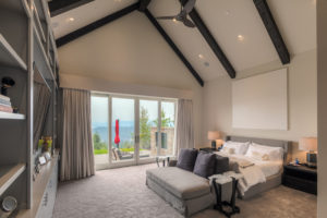 Modern bedroom with scenic view through glass doors.